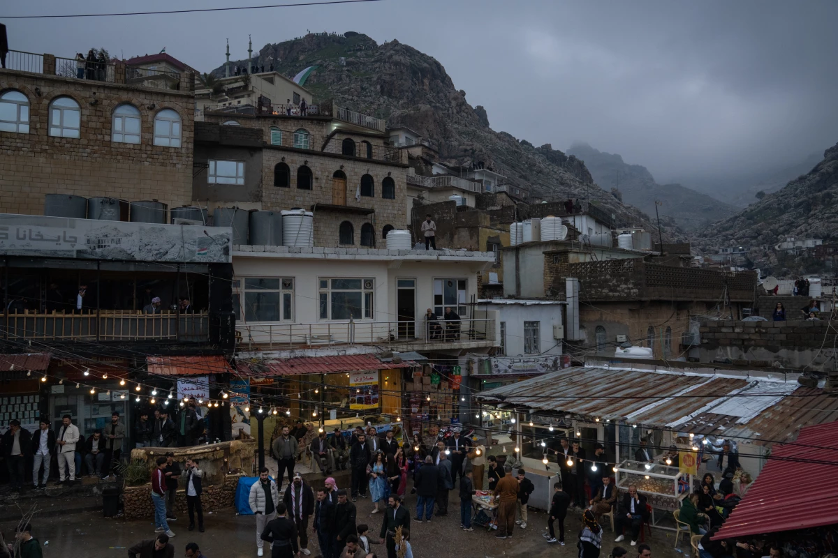 Dusk falls over Akre on Nowruz, a celebration of spring and renewal, and people gather in a central plaza.