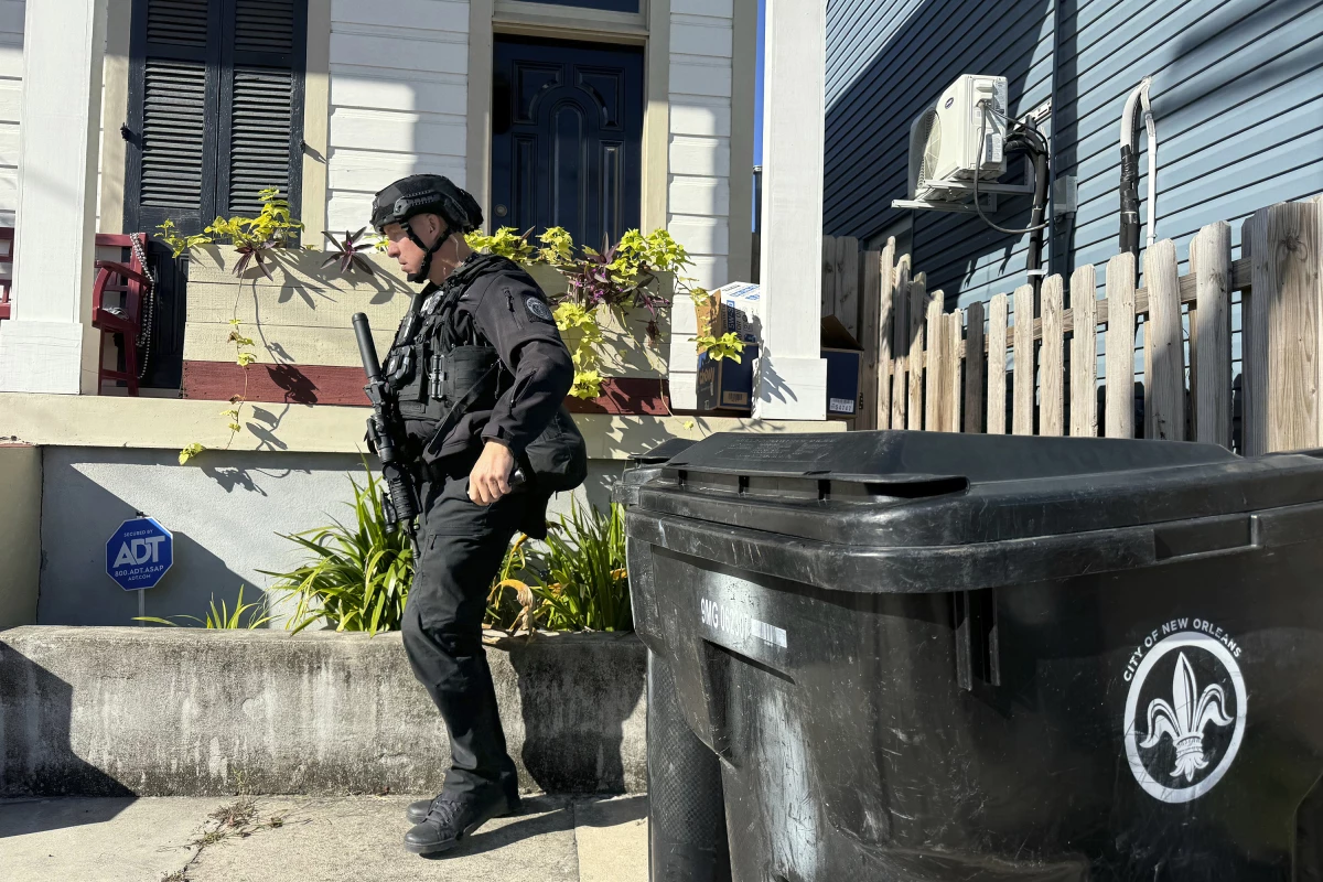 A New Orleans police officer searches the area near a crime scene after a vehicle drove into a crowd on Canal and Bourbon Street.