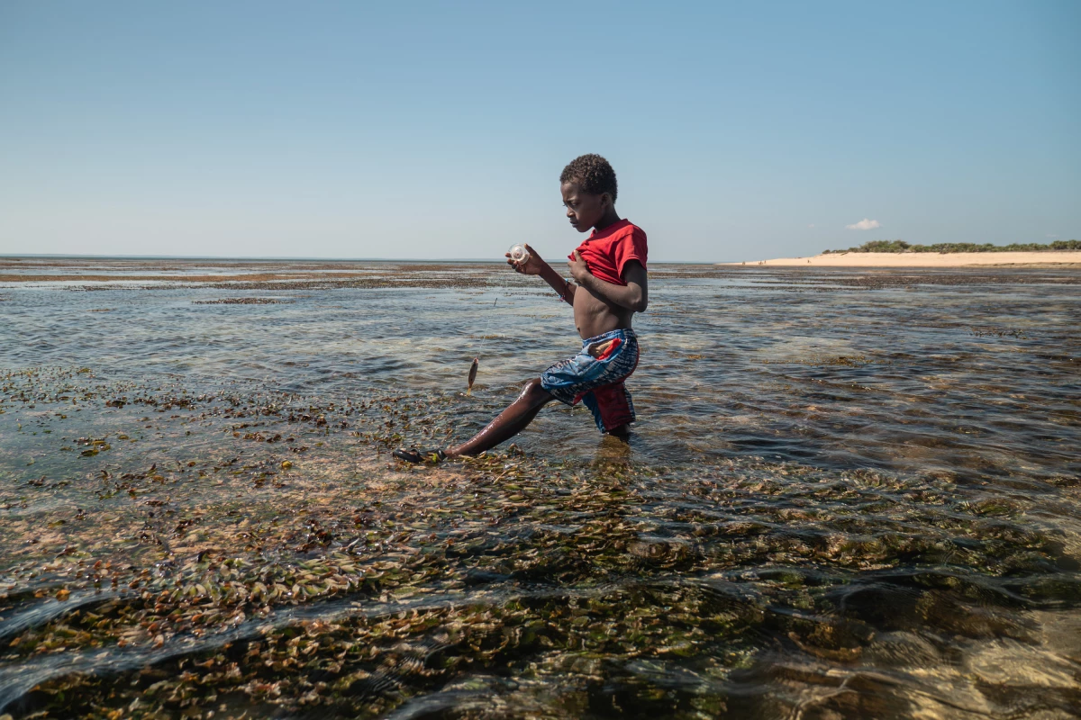 A child fishes with a string in the shallow waters of Nosy Maraontaly island, in Madagascar's Barren Isles.