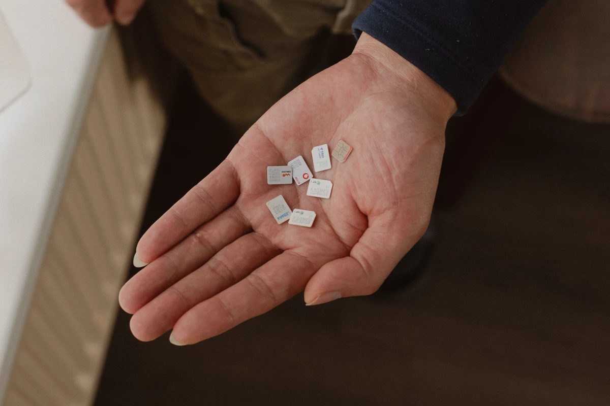 Gao Zhi displays cellphone SIM cards left behind by Wang Jingyu and Wang's girlfriend. Gao says he hosted the couple in his home for six months. He says Wang conned his family out of its life savings, which Wang denies.