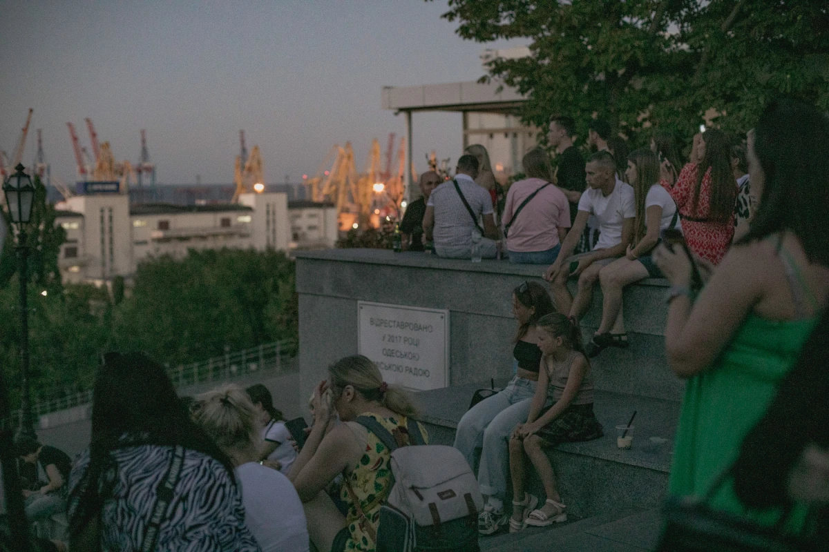 As evening falls on Aug. 14, people gather on the Potemkin Stairs, a well-known meeting place and venue for street musicians. The city's port can be seen in the distance.
