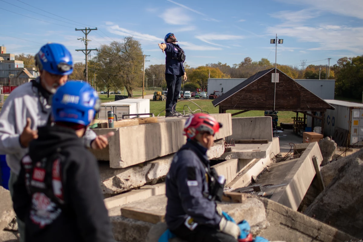 The 28 FEMA search and rescue teams that respond to disasters all over the country are as busy as they've ever been. Here, a search and rescue expert practices hand signals to communicate with a crane operator.