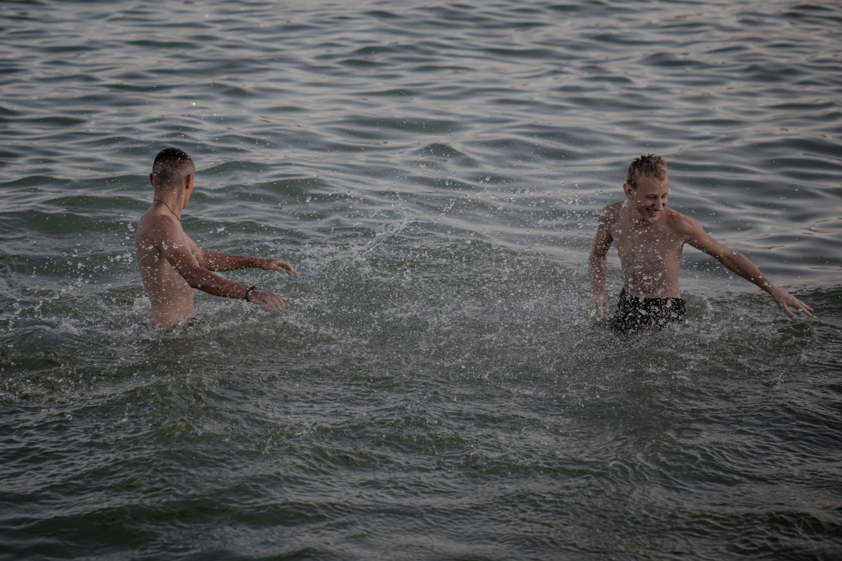 Boys play in the water in Odesa on Aug. 15. Until recently, people were hesitant to go into the sea or onto the beach due to fears of mines.