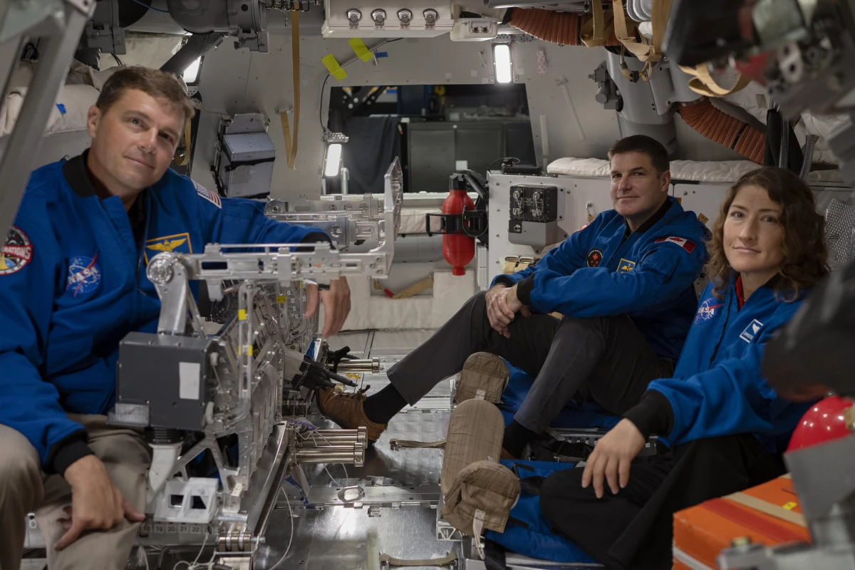 From left to right: Astronauts Reid Wiseman, Jeremy Hansen and Christina Koch settle in inside the Orion spacecraft mockup.