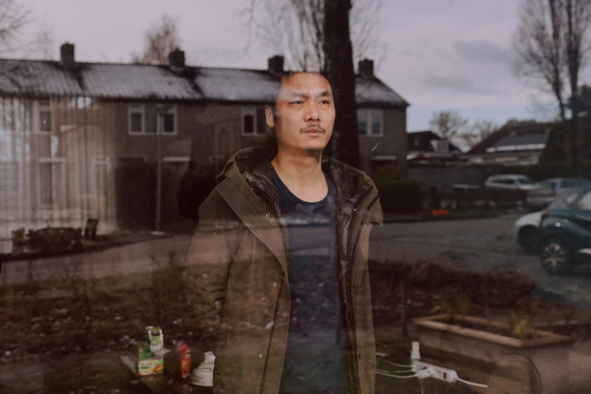 With his family stuck in Thailand, Chinese dissident Gao Zhi looks out the window of his home in a small village in the Netherlands.