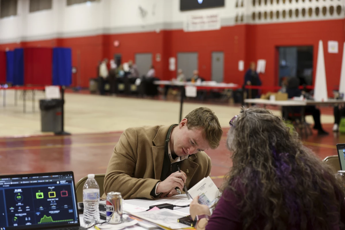 A voter registers to vote in Derry, N.H., on March 11. New Hampshire's March elections were the first test of the state's new proof-of-citizenship law.