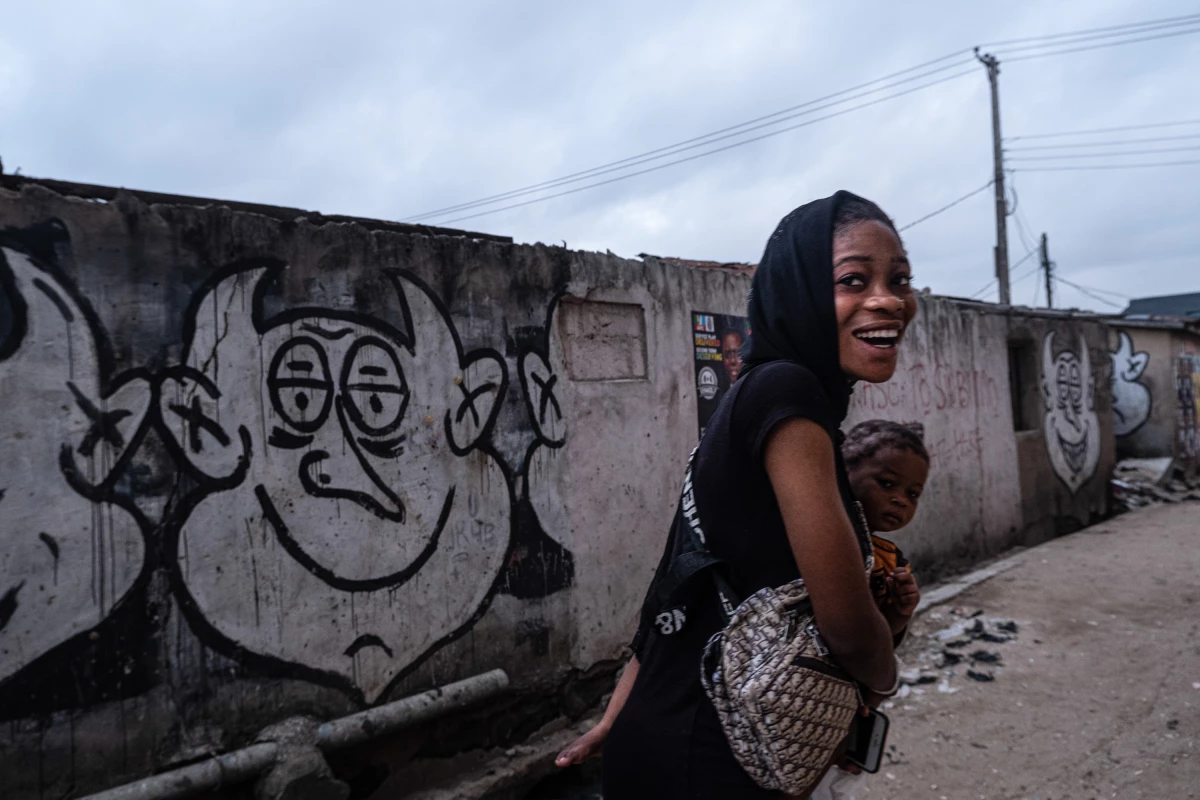 A woman takes a young girl to school in Bariga, Lagos. Photographer Fawaz Oyedeji says: 'I had just started shooting that calm morning for a project on election posters when she passed by carrying a girl and a schoolbag. Her unexpected smile set a friendly pace for the rest of my day in the field.'