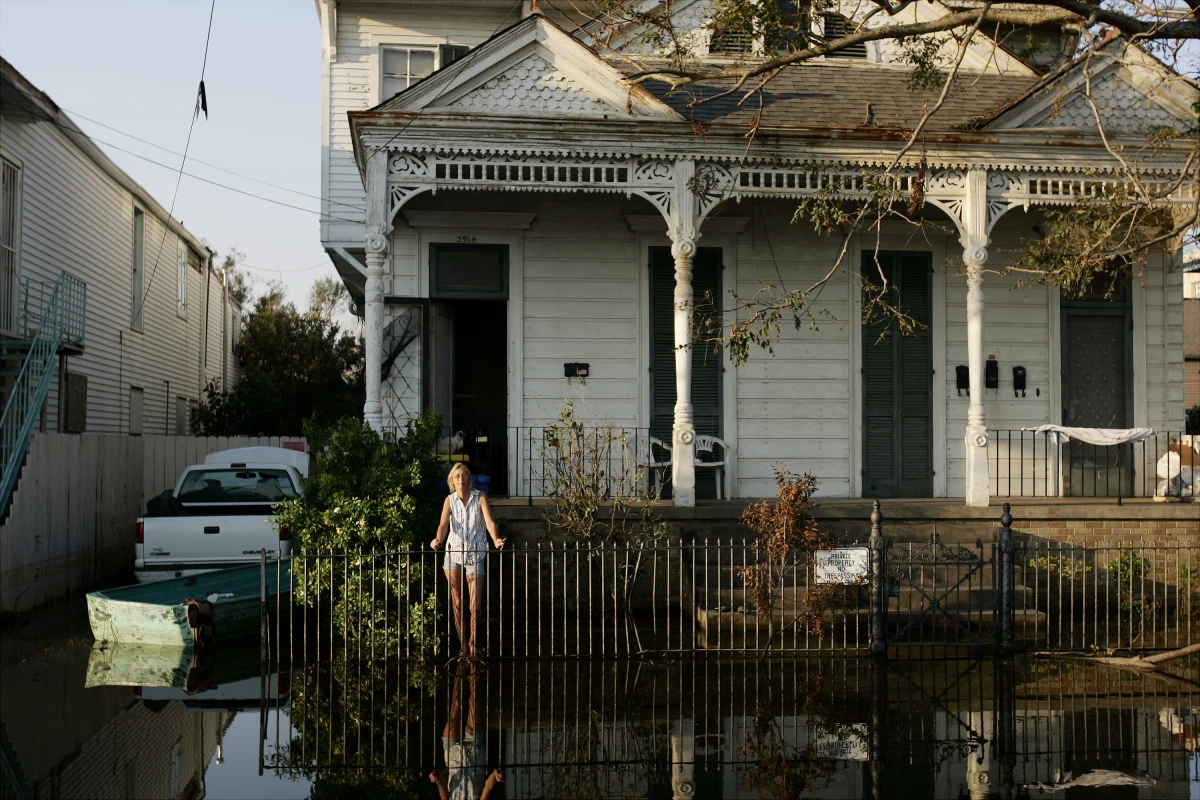 Kathy Smith, who chose not to evacuate the area because she learned she couldn't bring her cats along, stands in front of her home in the flooded 9th Ward neighborhood of New Orleans. As the city evacuated, already traumatized victims of Hurricane Katrina made a choice: Head for safety or stay behind with a beloved pet.