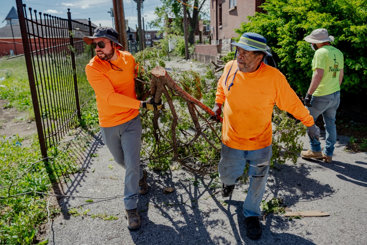 Alex Cadigan (left) helps Sam Campbell haul a large tree limb in north St. Louis on Saturday.