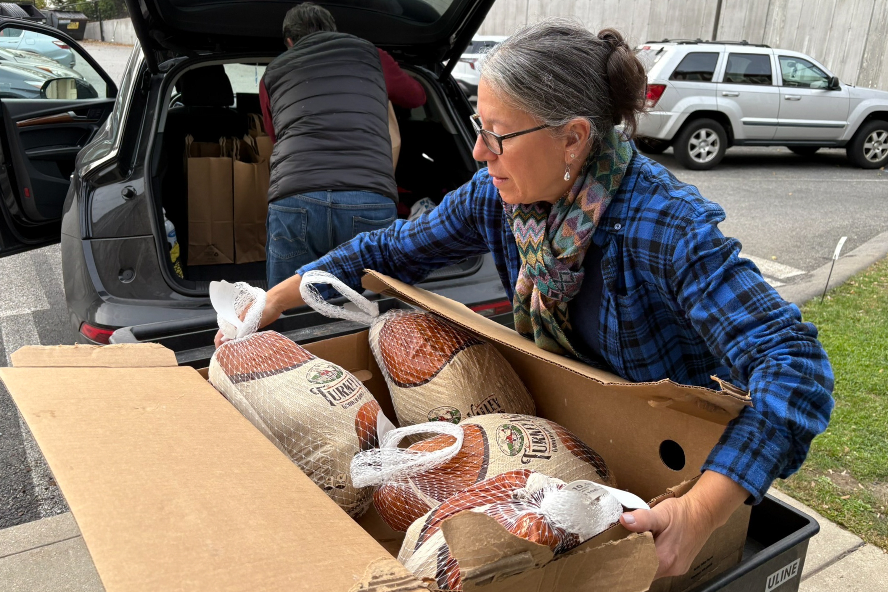 Julie Miller helps deliver frozen turkeys ahead of Thanksgiving. She is one of several volunteers helping the ABCD Allston/Brighton Neighborhood Opportunity Center in Boston. Demand there has spiked since SNAP benefits have lapsed, and some people looking for food assistance have to wait two weeks for help. (NPR)