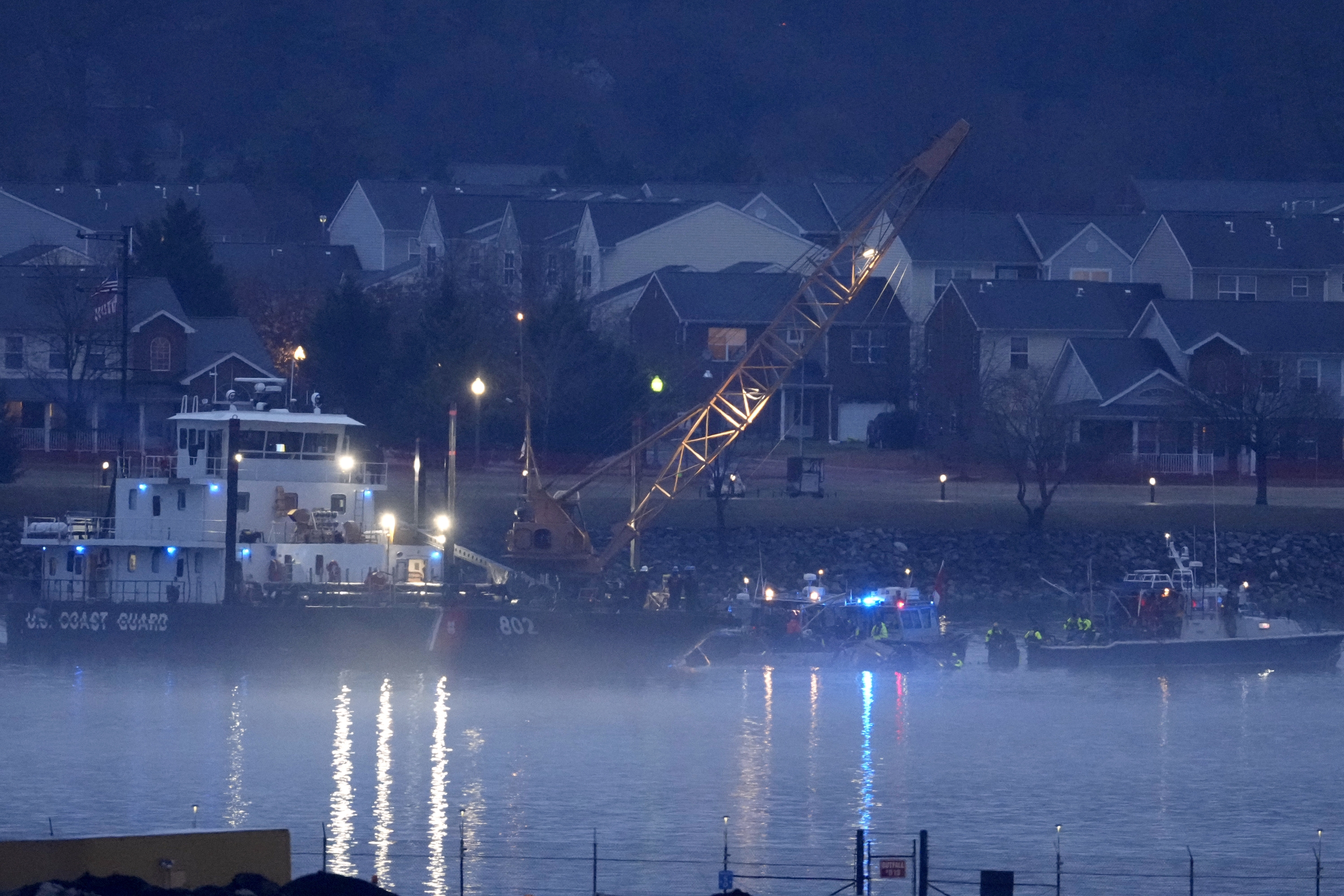 Fog surrounds a Coast Guard vessel with a crane as it works near the wreckage of a Black Hawk helicopter in the Potomac River on Friday near Ronald Reagan Washington National Airport in Arlington, Va. (AP)