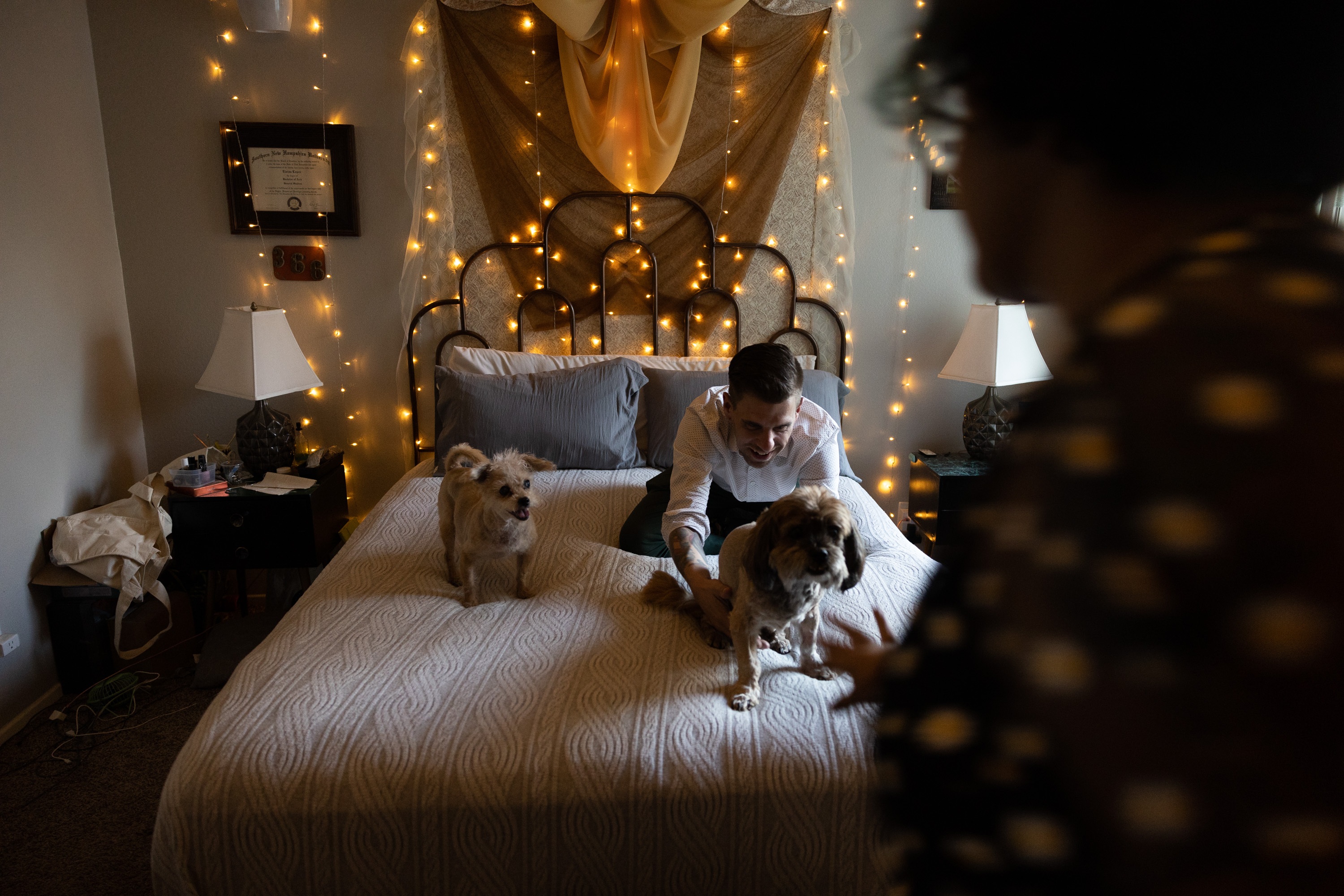 Thomas Guzowski greets his dogs, 13-year-old Mali and 15-year-old Yaretzi, as they climb onto the bed.
