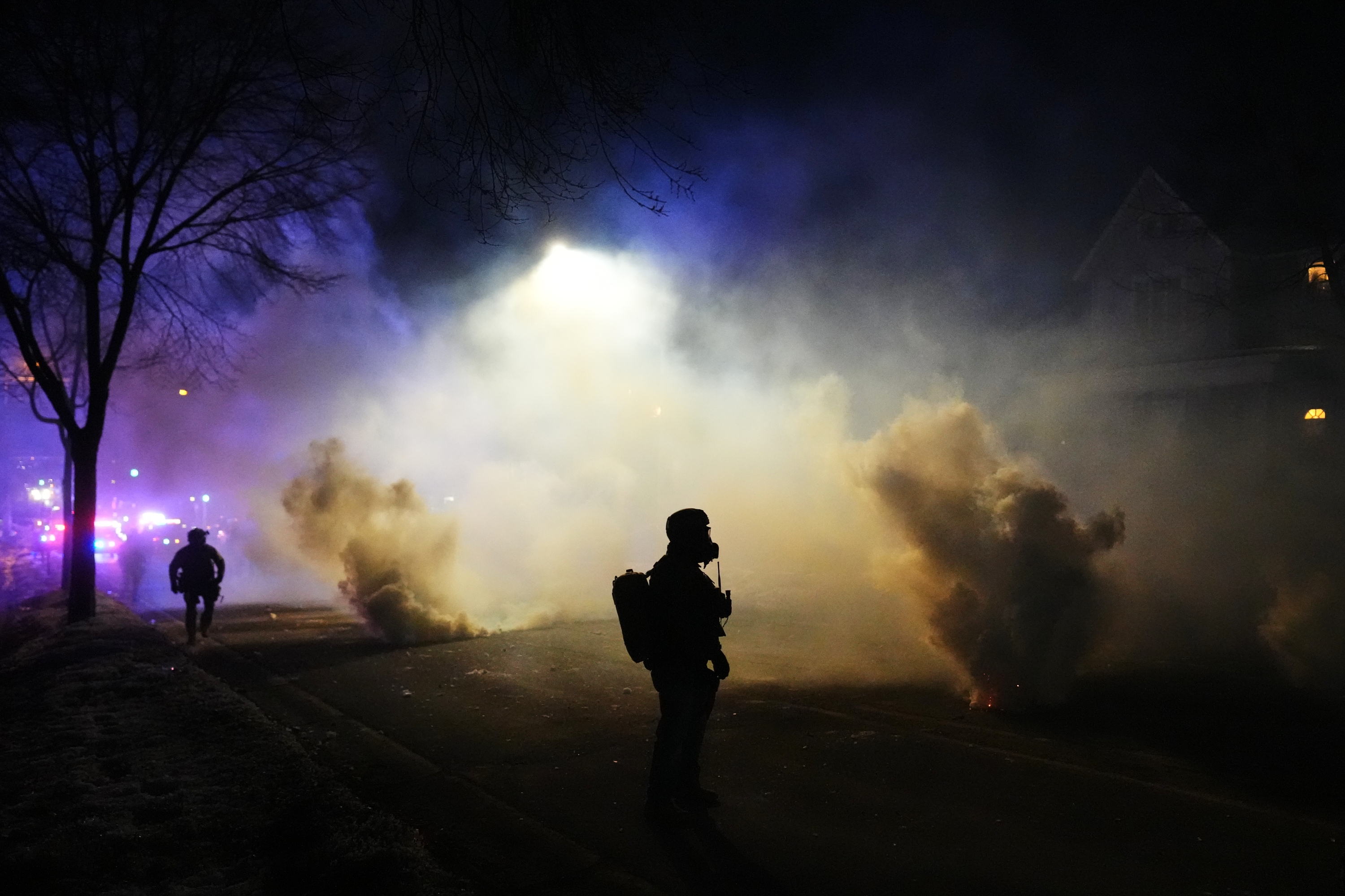 Law enforcement officers stand amid tear gas at the scene of a shooting Wednesday in Minneapolis. (AP)