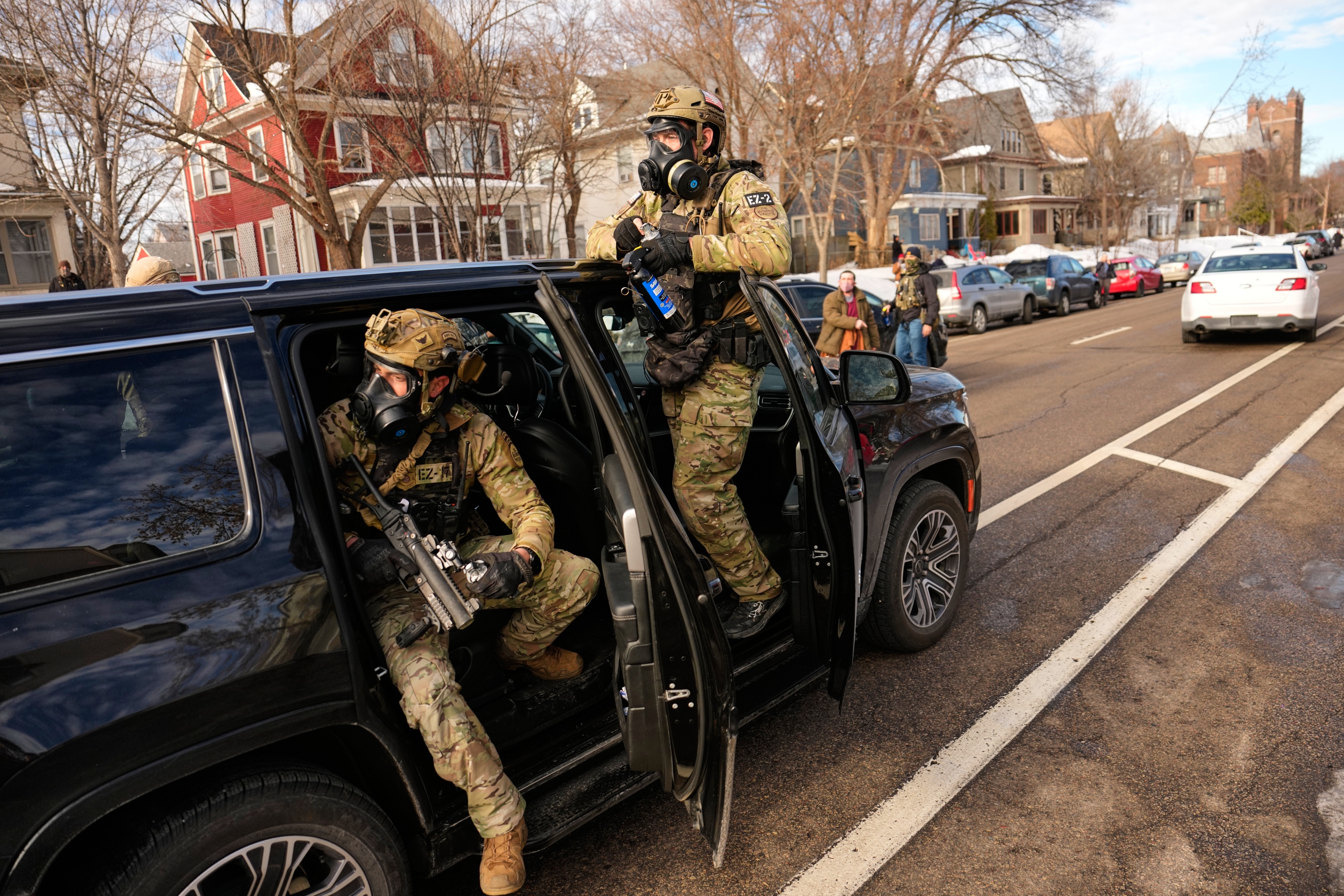 Federal immigration officers get in a car as they prepare to deploy tear gas at a protest Monday in Minneapolis.