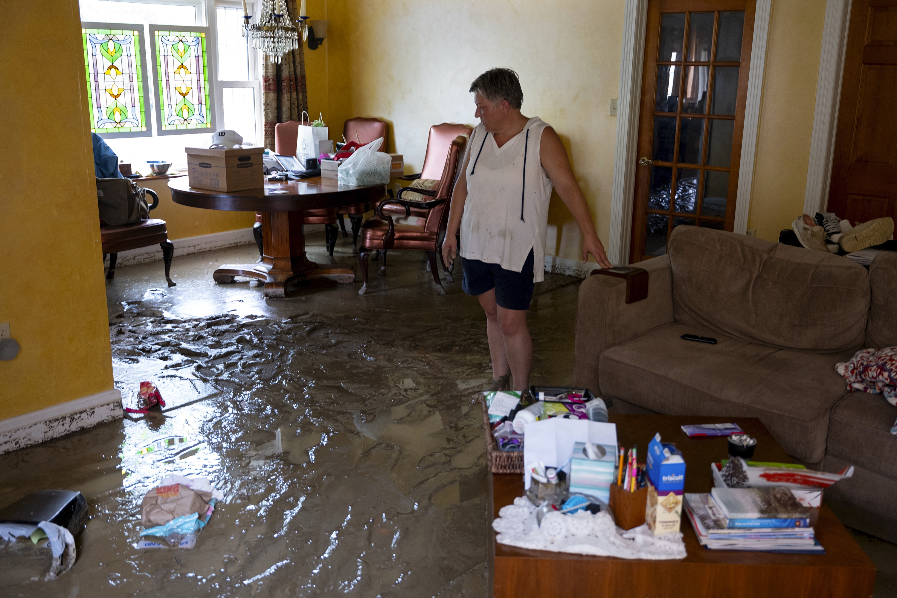 Ann Farkas walks in her flood-damaged home in Canisteo, N.Y., Friday, after remnants of Tropical Storm Debby swept through the area, creating flash flood conditions in some areas.