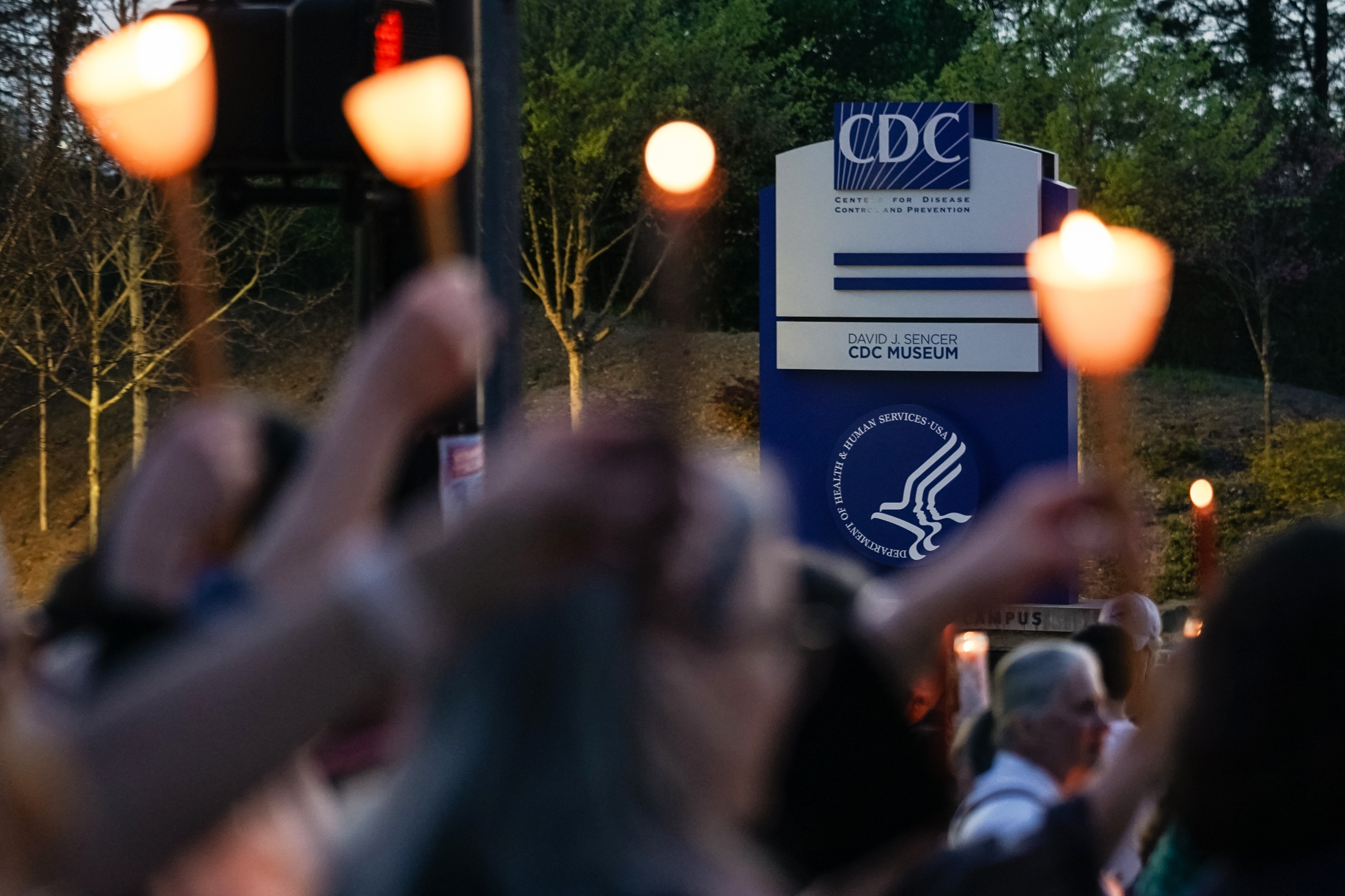 People participate in a candlelight vigil in front of the main offices of the Centers for Disease Control in Atlanta on March 28, days before thousands of CDC employees were laid off.