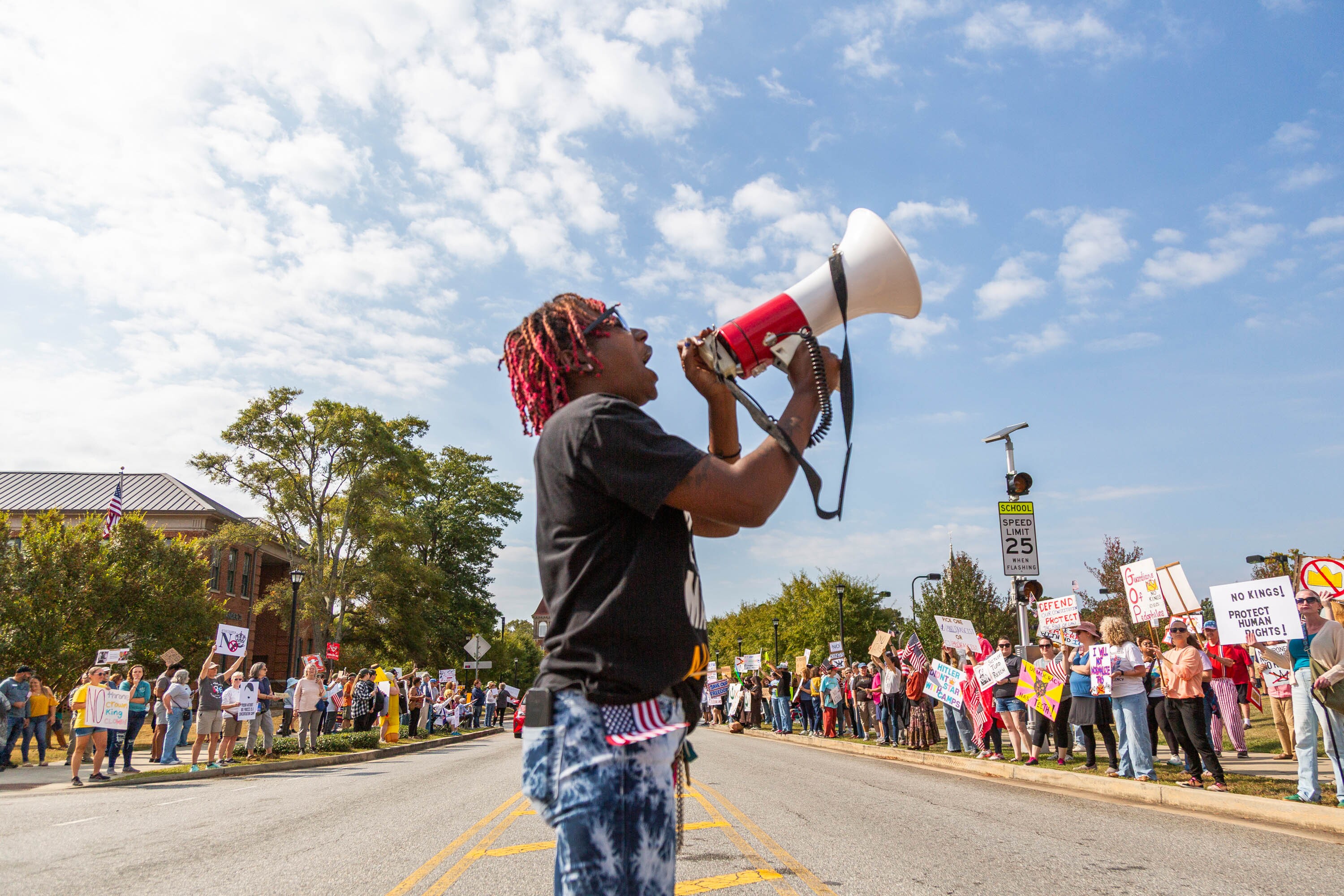 Legacee Medina of Macon, Ga. leads chanting at a No Kings rally between an elementary school and pickleball courts in Macon on October 18, 2025. The rally moved from its earlier location downtown to stay out of the way of a planned Hispanic festival.