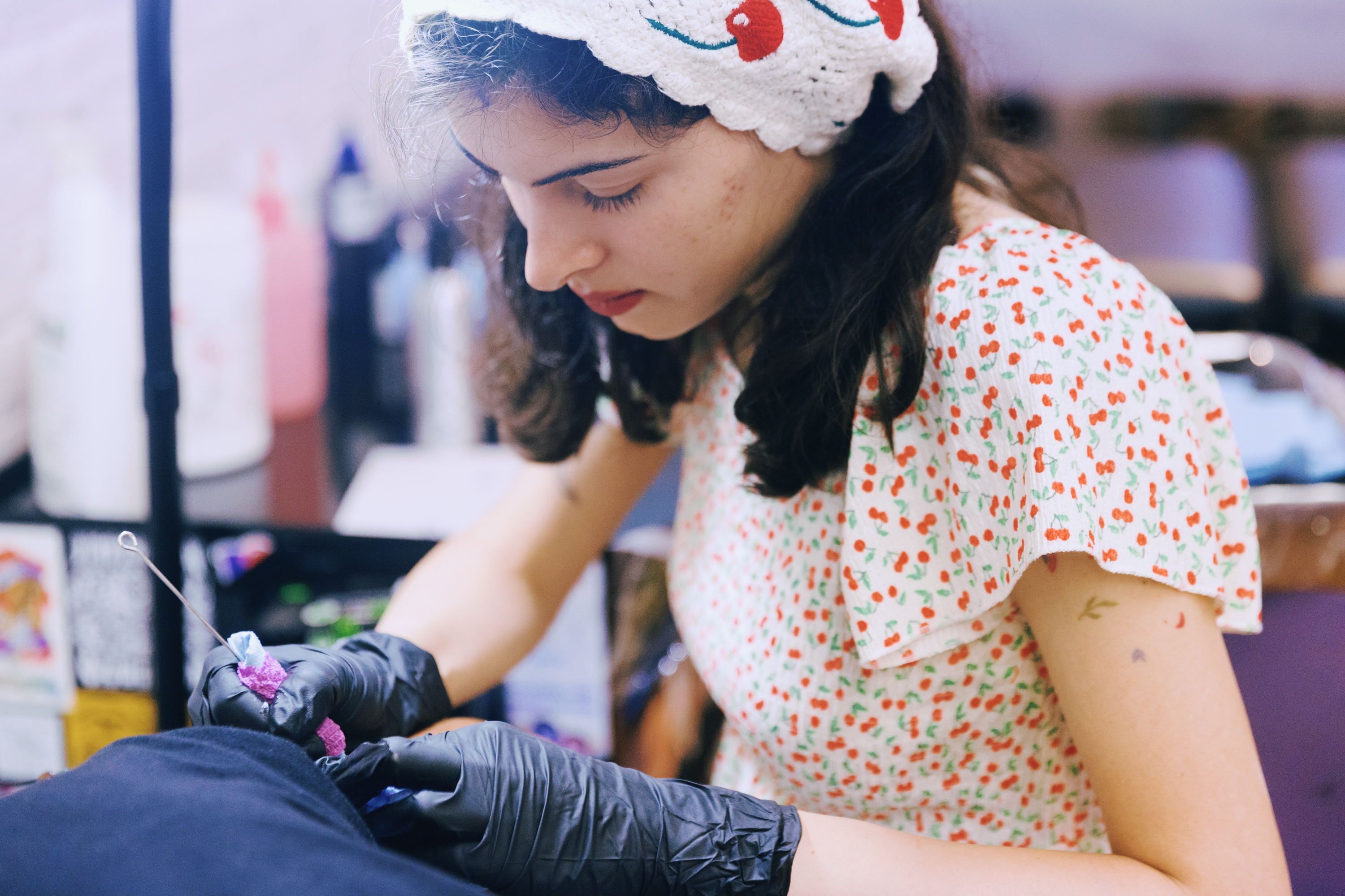 Abby Ingwersen, a guest artist at Nice Try Tattoo, works on a client using the stick and poke method.