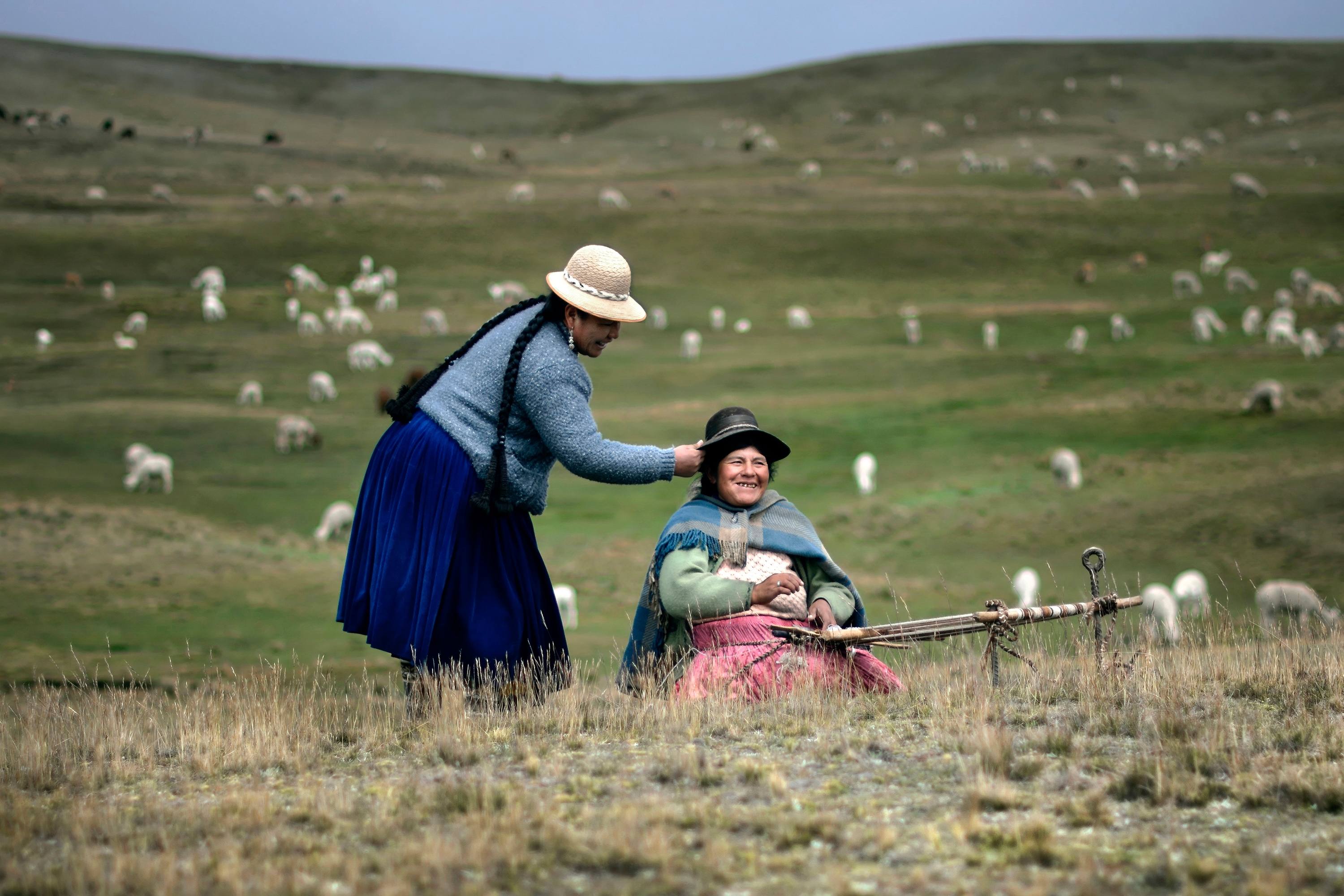 The smallest gesture can be imbued with kindness. In Puno, Peru, Maria adjusts her friend Rosa