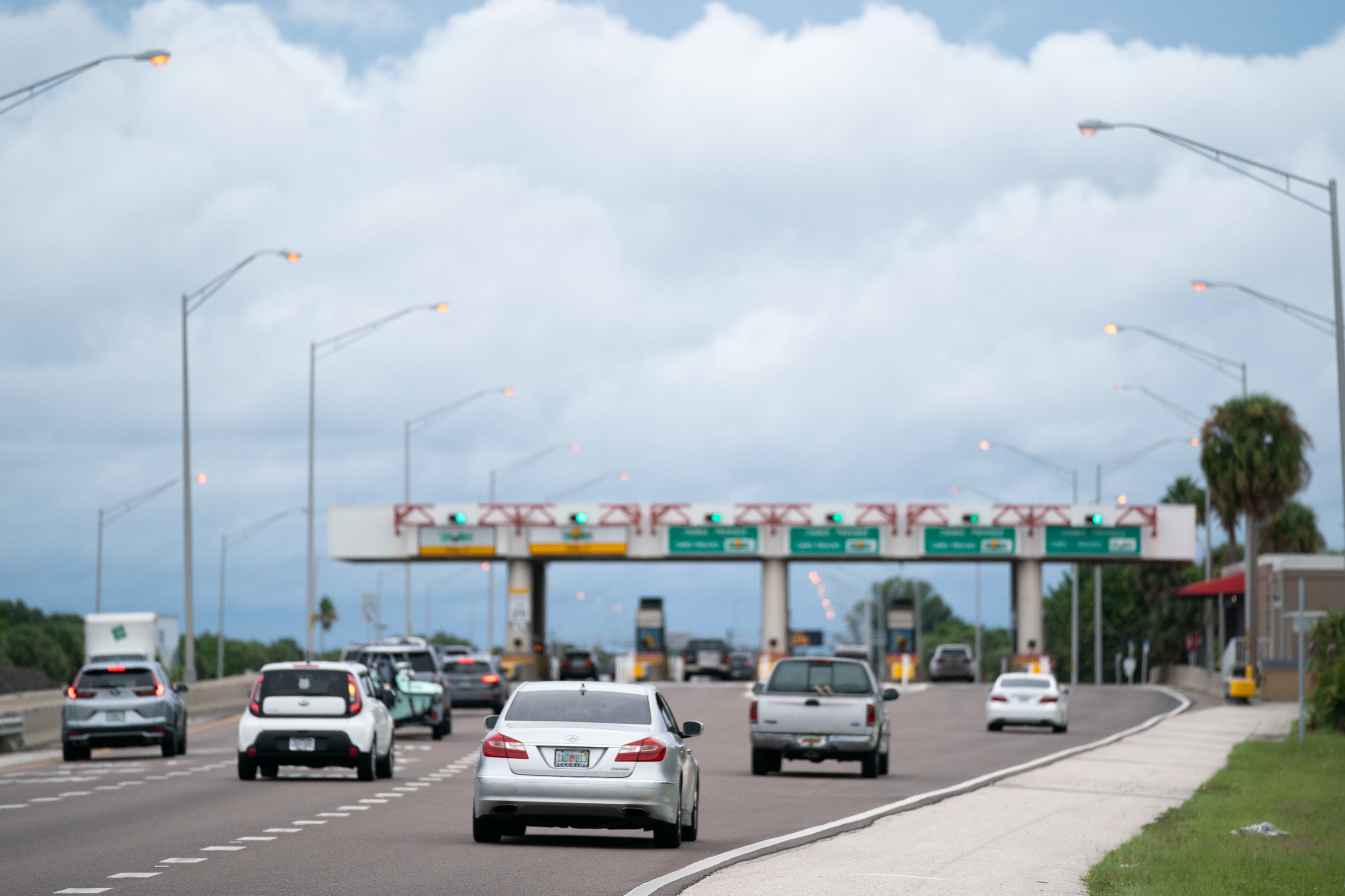 Motorists pass through a toll plaza near St. Petersburg, Florida. Bogus text messages threatening phone users with unpaid toll fees have spread rapidly — in part because scammers try to benefit from trends in travel and congestion pricing, an expert tells NPR.
