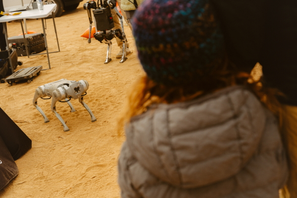 Festival attendees watch a robotic dog in action.