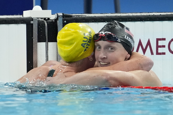Ariarne Titmus, of Australia, left, celebrates after winning the women's 400-meter freestyle final with Katie Ledecky, of the United States, at the 2024 Summer Olympics, Saturday, July 27, 2024, in Nanterre, France. (AP Photo/Matthias Schrader)