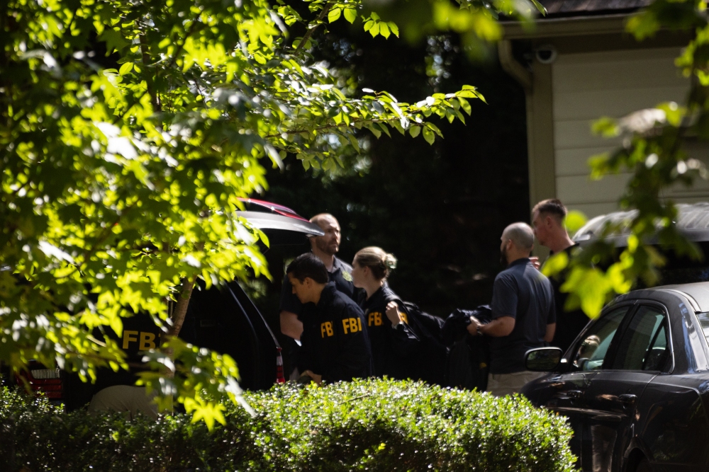 FBI officers exit and re-enter the home of former Trump national security adviser John Bolton, in Bethesda, MD on August 22, 2025. (NPR)
