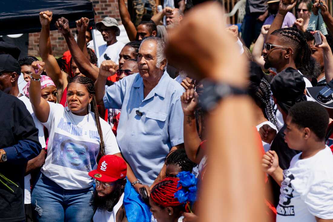 U.S. Rep. Cori Bush, D-St. Louis County, rests her arm on Michael Brown Sr. on Friday, Aug. 9, 2024, during a memorial commemorating a decade after Michael Brown Jr.’s police killing in Ferguson.