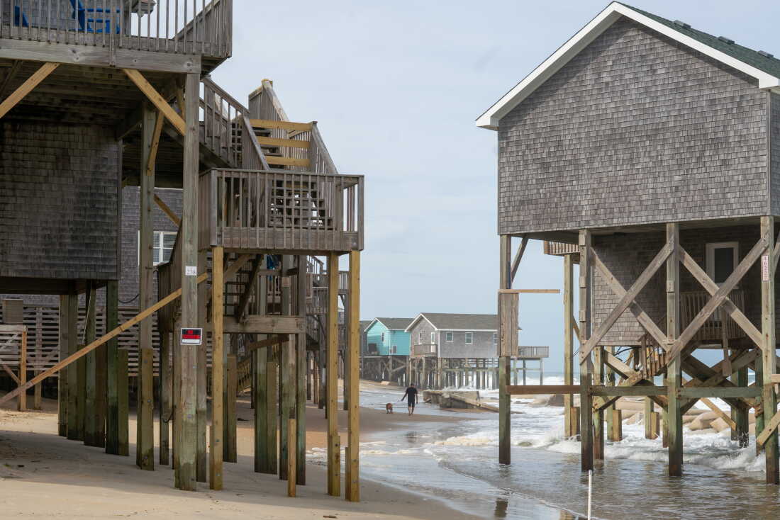 Ocean waves wash under beachfront houses that stand on wooden stilts in Buxton, North Carolina, in May.