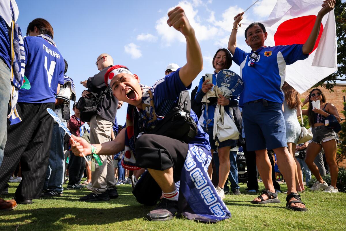 Toshiki Hayashi (center) and other fans cheer for Japan at a Paint It Blue event before the World Cup game Wednesday, June 24, at Harwood Park in Dallas.