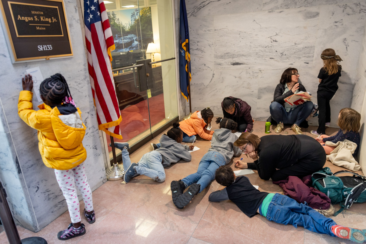 Students and parents from Washington, D.C.'s Elsie Whitlow Stokes Community Freedom Public Charter School, East End Campus, write letters outside of the office of Sen. Angus King, I-Maine. They handed those letters to the staff in order to convince the member to vote 'no.'