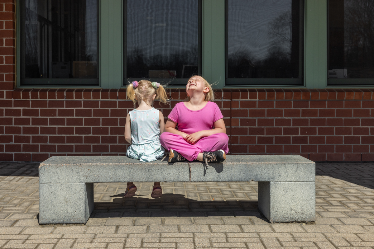 Second grader Mia Martin (right) shares a moment outside of school with younger sister Sophia Martin, who is not yet school age.