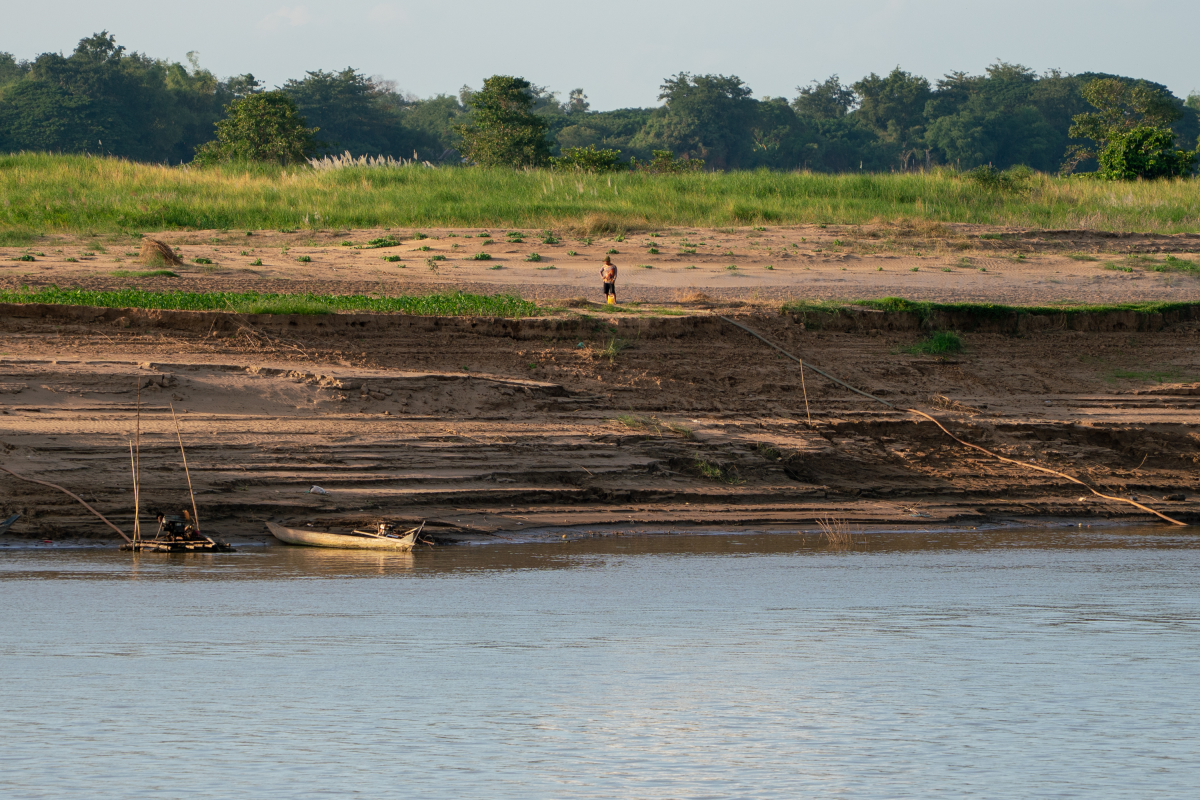 A man stands at the top of a steep bank of the Mekong River near Roka Thom village in central Cambodia.
