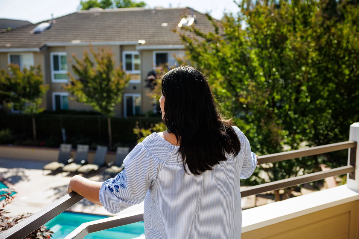 E. stands on the balcony of her apartment in Concord, Calif., on June 12, 2025.