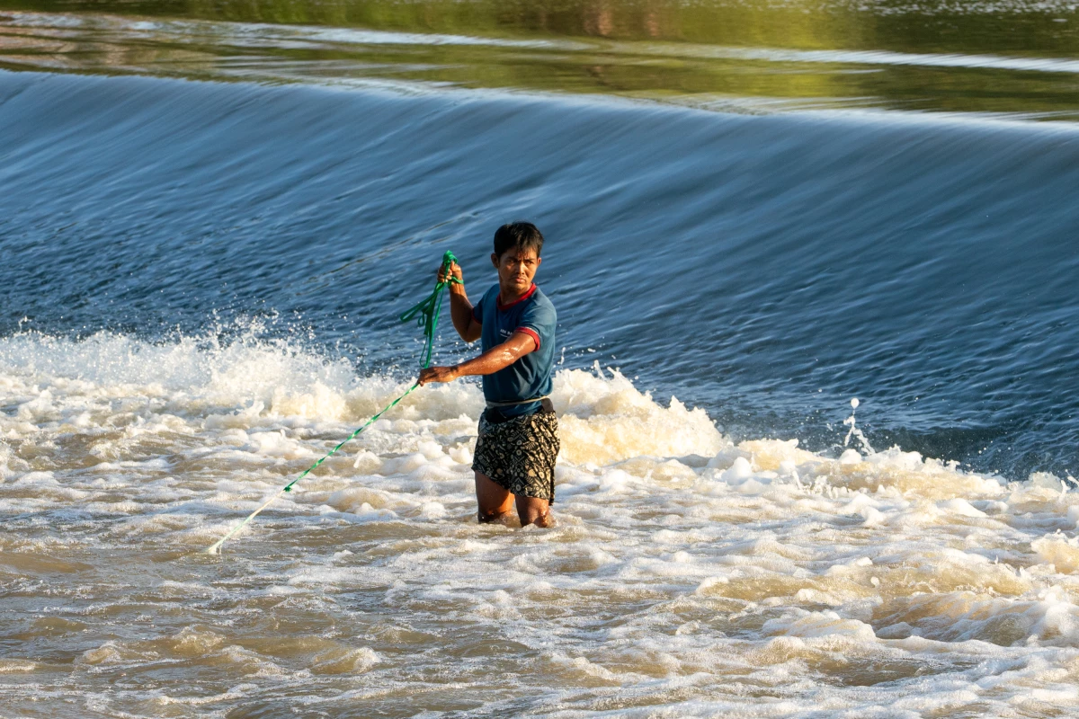 Fishermen use nets to catch fish in central Cambodia's Pursat River. Recent flooding of the river has disrupted life and destroyed crops. But weather warnings have allowed residents to evacuate or seek high ground before the water arrives.