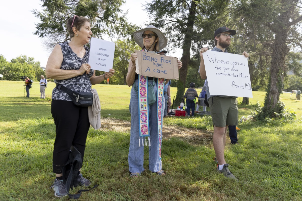 Members of faith communities showed up with signs to support the unhoused people being vacated from the encampment.
