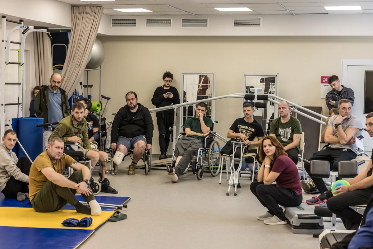 Injured soldiers at the Recovery rehabilitation center listen to Oleksandr Budko, a 28-year-old veteran, in Kyiv, Ukraine, on Oct. 18. During his visits to rehabs, soldiers ask Budko lots of practical questions about things like prosthetics and health care.