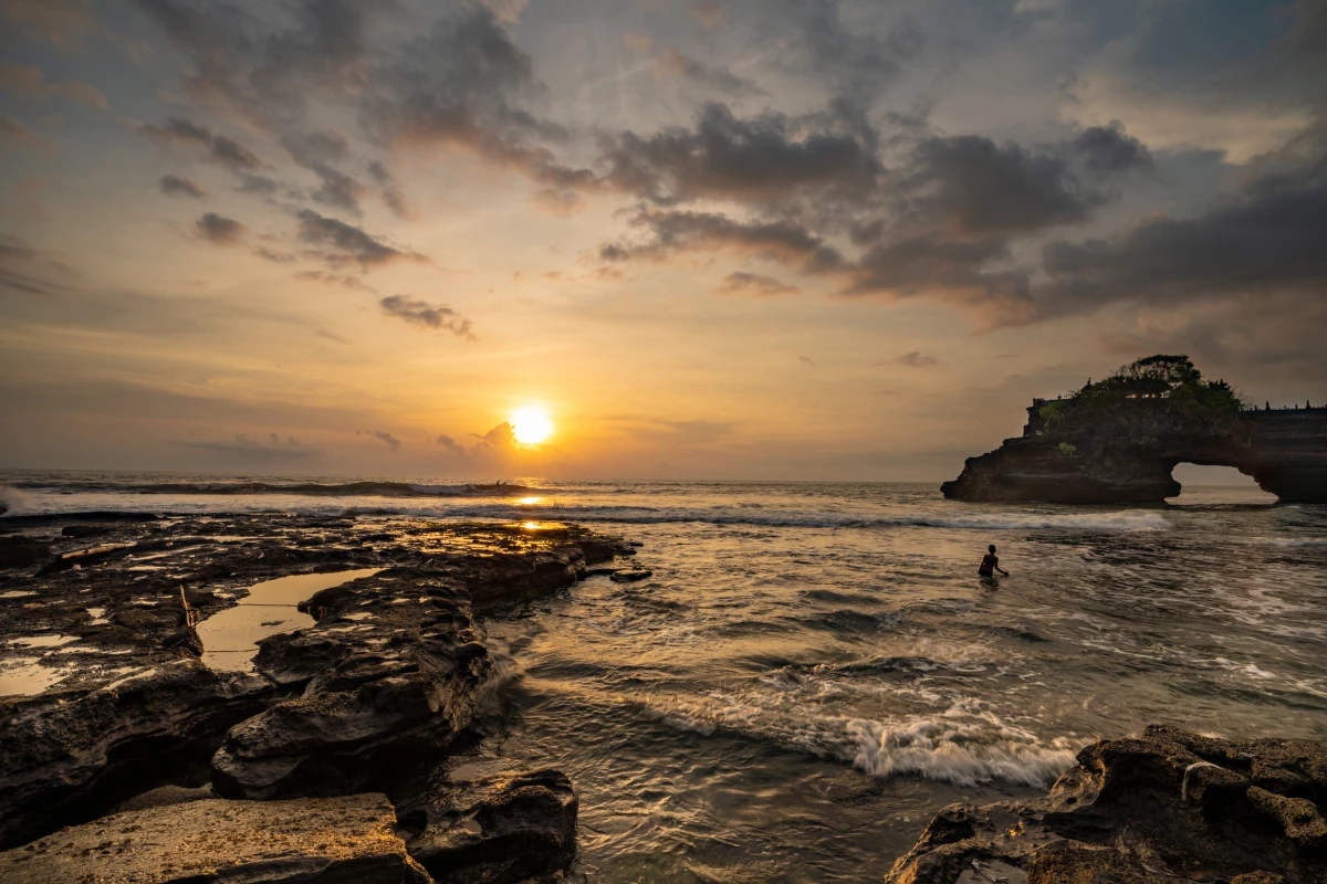 A child plays in the sea near the Pura Batu Bolong Hindu temple at Bali, Indonesia, located on the natural arch bridge. Photographer Amrita Chandradas was 'in awe' of the intricate rock formations '' and says the sight of the child 'frolicking among the waves' created 'a moment of pure tranquility.'