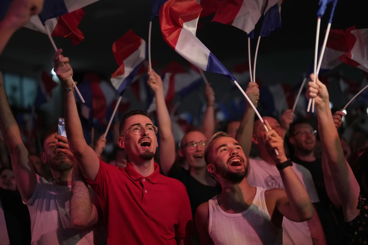Supporters of French far-right leader Marine Le Pen react after vote projections in select constituencies, Sunday, in Henin-Beaumont, northern France. French voters propelled the far-right National Rally to a strong lead in first-round legislative elections Sunday and plunged the country into political uncertainty.