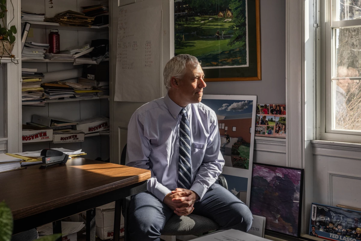 Superintendent Jonathan Moody, of the MSAD 54 school district, looks out of the window of his office, which is housed in a converted farmhouse.