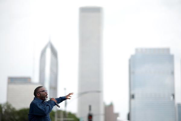 This spring Chicago’s city council approved mayor Brandon Johnson’s “Green Social Housing” ordinance. It will spur the development of new affordable housing that reduces climate pollution. Here Johnson speaks into a microphone while the Chicago skyline can be seen behind him.