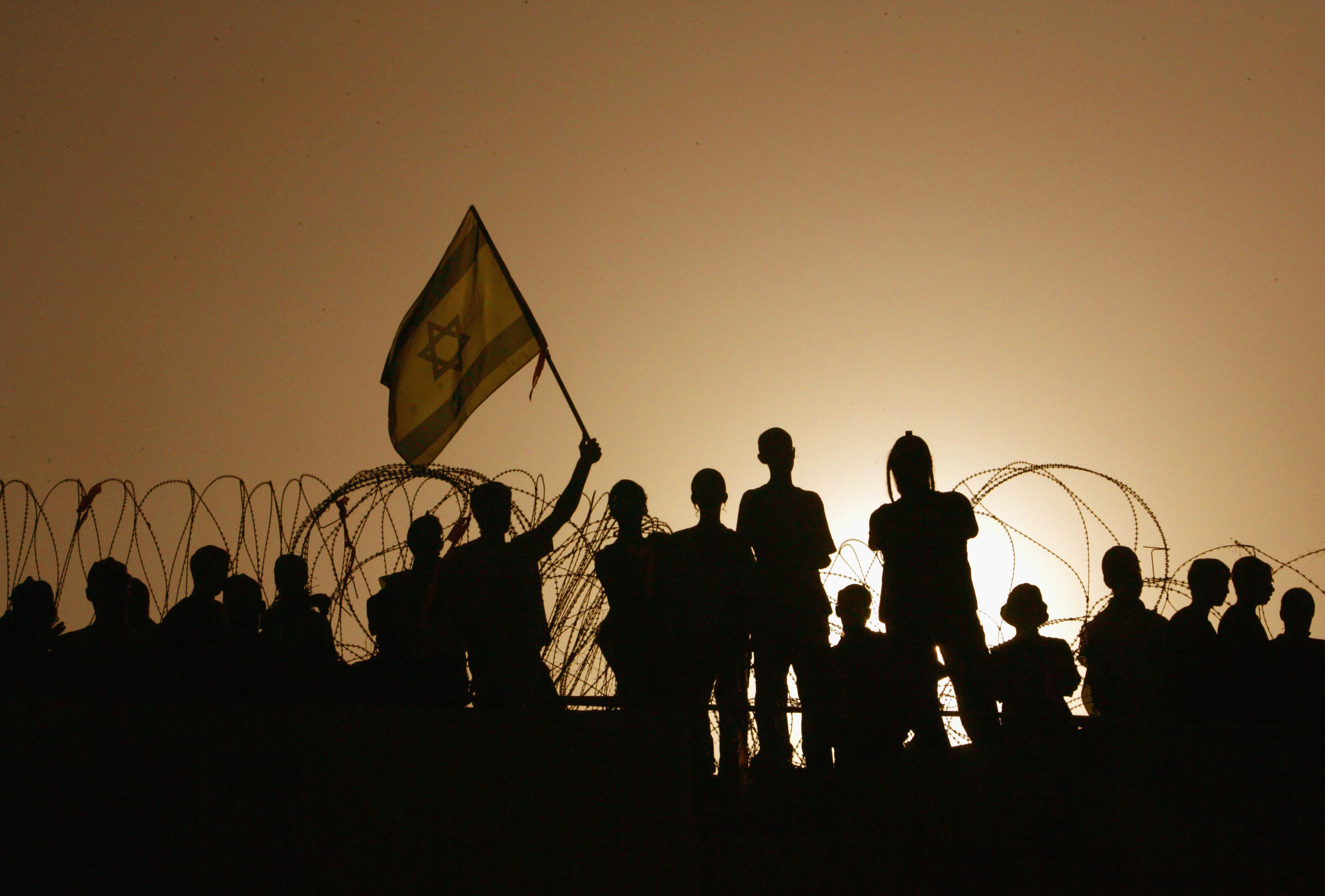 Militant Jewish settlers barricade themselves on the roof of their synagogue as hundreds of Israeli troops and police deploy at sunrise to evacuate the veteran Jewish community of Kfar Darom in the Gaza Strip, on Aug. 18, 2005.