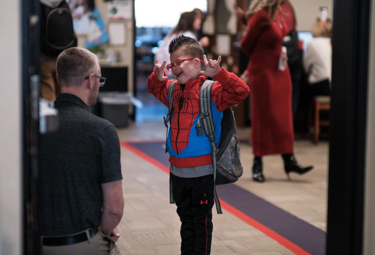 Kellen greets his teacher, Mr. Frederick, at the beginning of the school day.