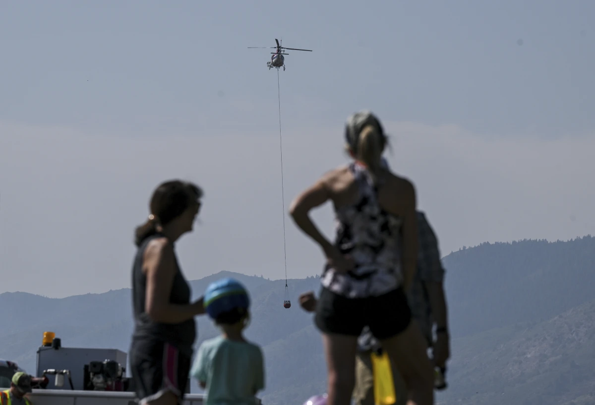 Onlookers watch while crews work near the Ken Caryl Ranch development as the Quarry fire burns Thursday, Aug. 1, 2024, southwest of Littleton, Colo.