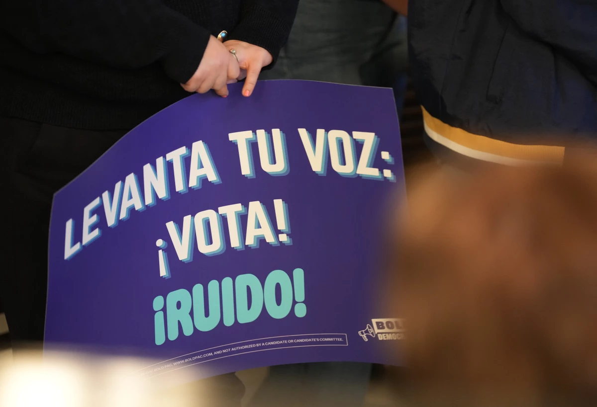 A person holds a sign saying 'Raise your voice: Vote' at a creator event for BOLD Democrats, a Hispanic PAC, in Houston on Feb. 17. Democrats think they may have a chance to sway Latino voters who supported President Trump two years ago.