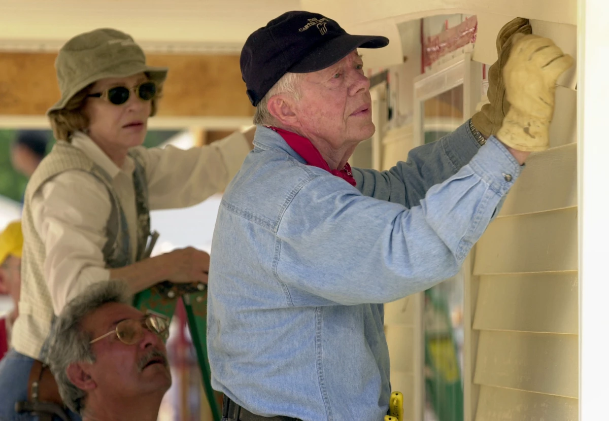 Former President Jimmy Carter and his wife, Rosalynn Carter, attach siding to the front of a Habitat for Humanity home being built on June 10, 2003, in LaGrange, Georgia.