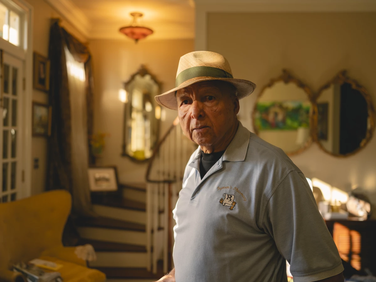 Adolph Bynum, 86, the founder of the Bynum's Pharmacy, at his house in the Treme in New Orleans, Louisiana, on Tuesday August 26th, 2025. Bynum's pharmacy (the second black owned pharmacy in New Orleans) ran for 40 years and was a central place for the upper 9th Ward community. The pharmacy was washed away by Hurricane Katrina. Camille Farrah Lenain for NPR.