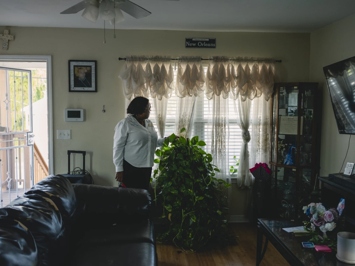 Marguerite Doyle Johnston touching the plant she started growing after her son, Chivas, was killed on January 13th 2007 while living in a FEMA trailer next door.