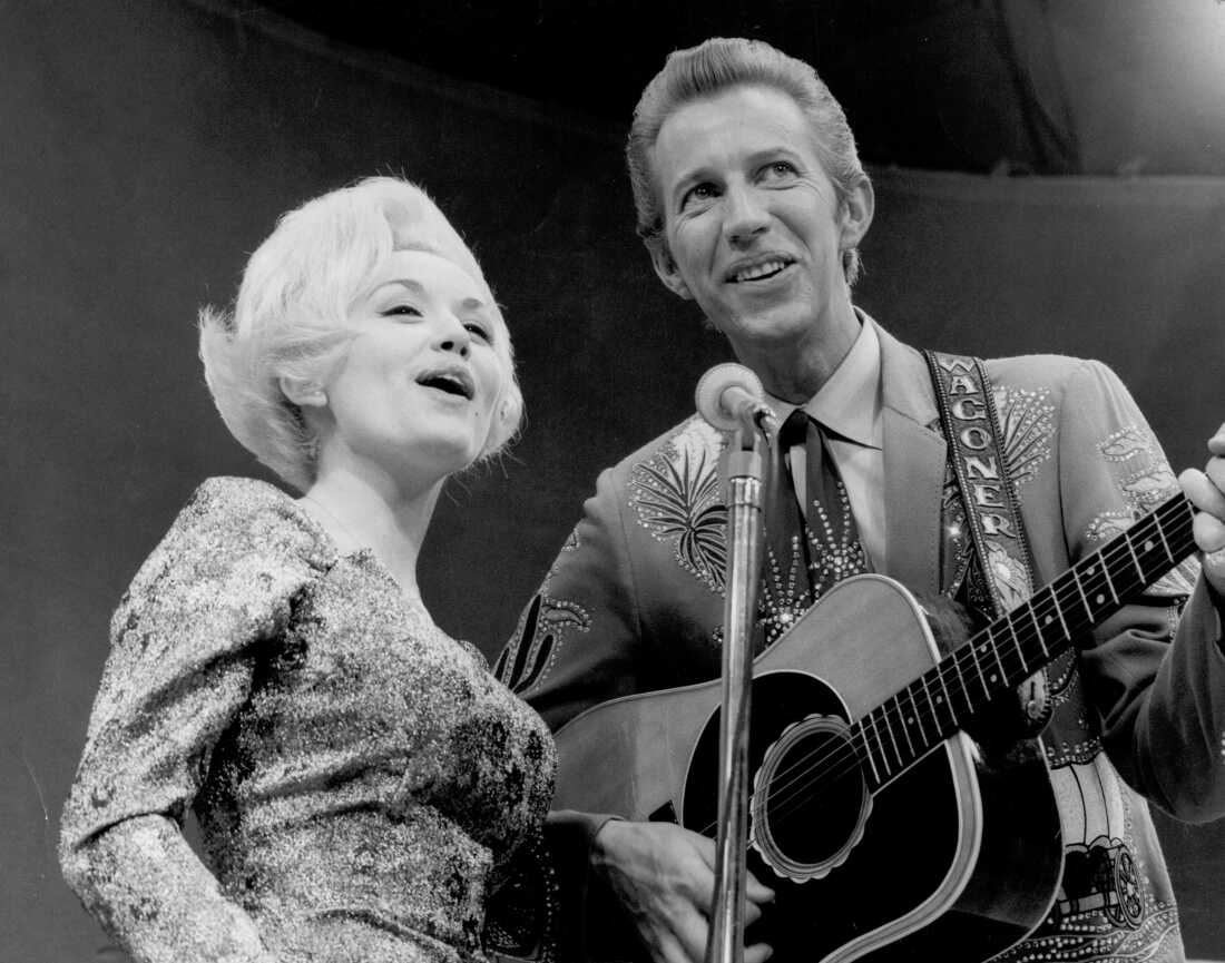Country singer Dolly Parton and her collaborator Porter Wagoner perform onstage in circa 1967. Mr. Wagoner is wearing a Nudie Suit designed by Nudie Cohn of Nudie's Rodeo Tailors.
