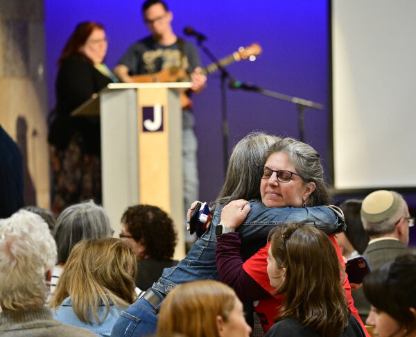 People⁤ embrace ⁢at a vigil after an attack in ‍Boulder, Colo.